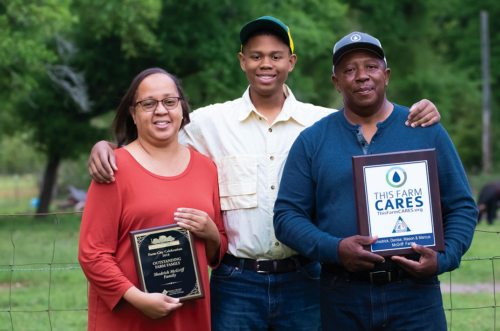 Three people face the camera. Two have CARES awards.