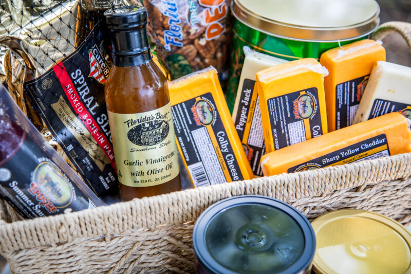 Basket filled with Florida-made food products including cheese, vinegar, olive oil, and specialty snacks