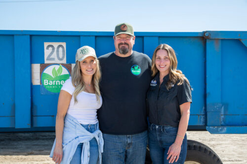 Members of the Barnes family standing in front of a Barnes Farms container at Barnes Farms in St. Johns County
