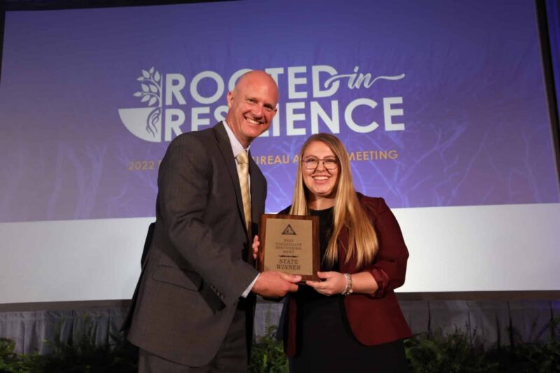 Maddie Dvorak, University of Florida student and collegiate discussion meet winner, poses on stage with FFBF President Jeb S. Smith.