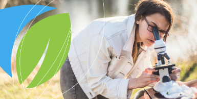 Woman looking through microscope with AEST logo.